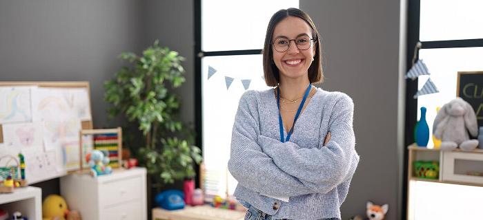 A preschool teacher smiling at the camera